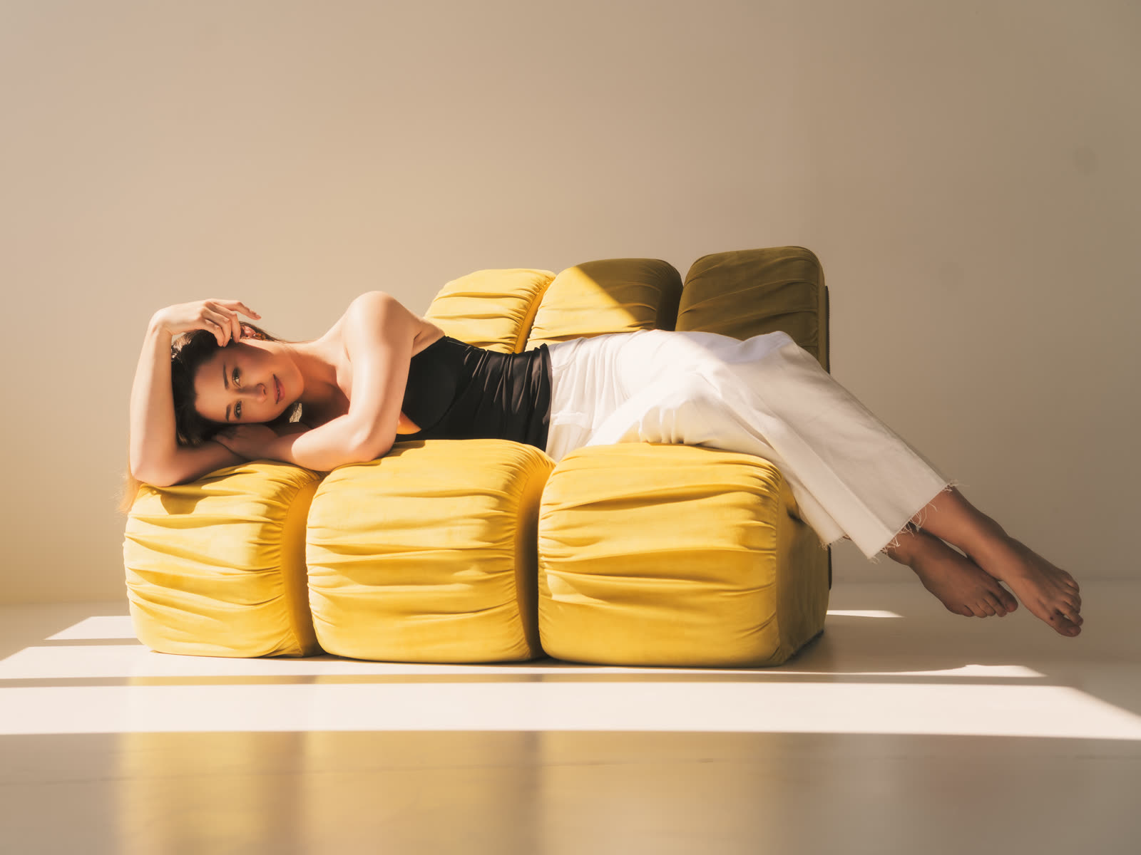 Editorial — modelka na żółtej sofie w sesji fashion w krakowskim studiu